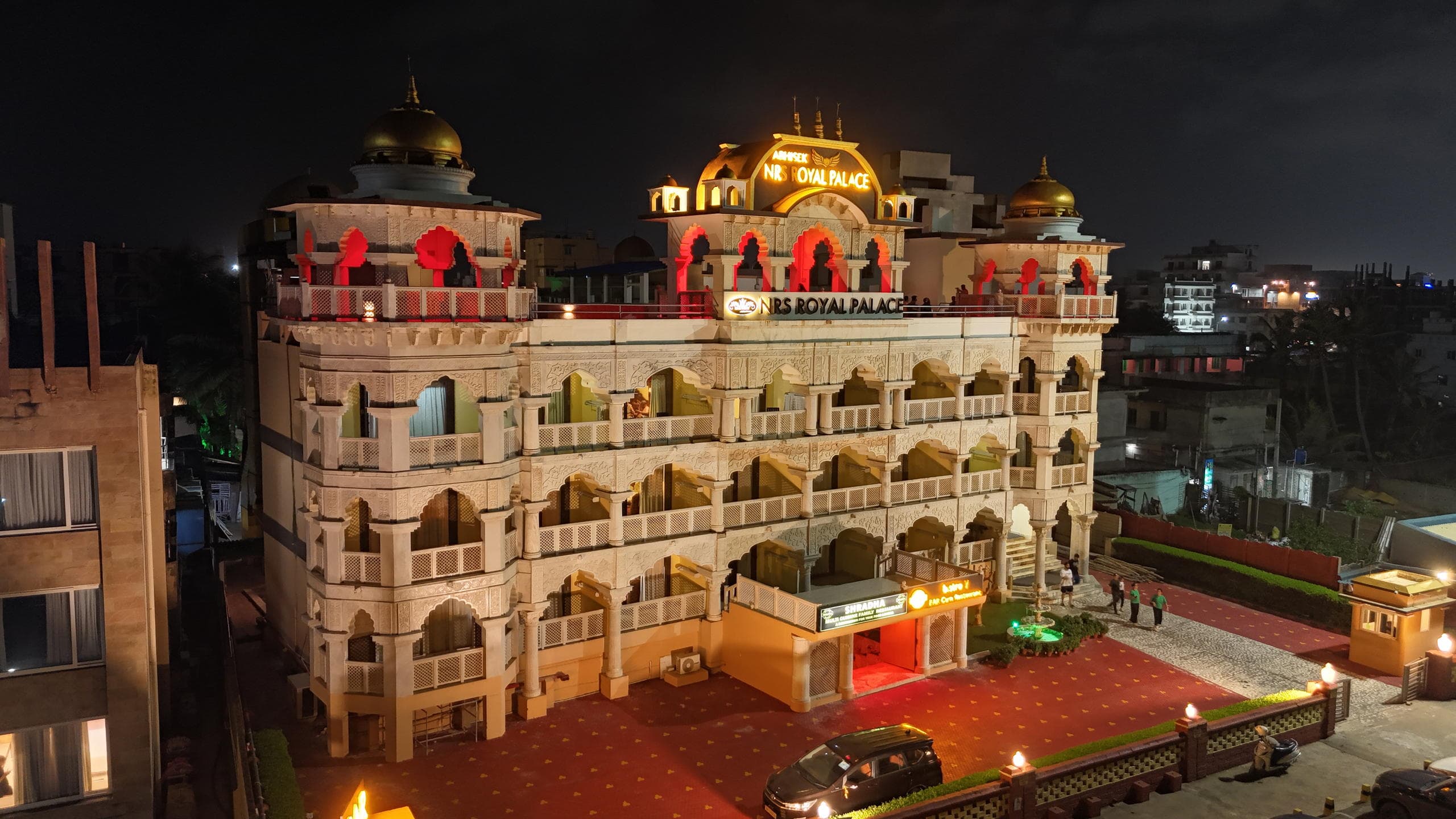Night elevation showing gilded domes and red-lit arches